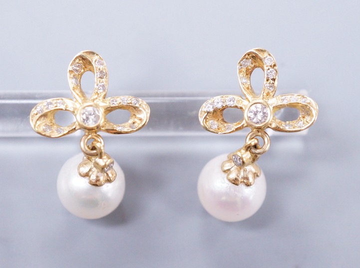 A modern pair of 18k yellow metal, cultured pearl and diamond cluster set drop earrings, 21mm, gross weight 4.3 grams.